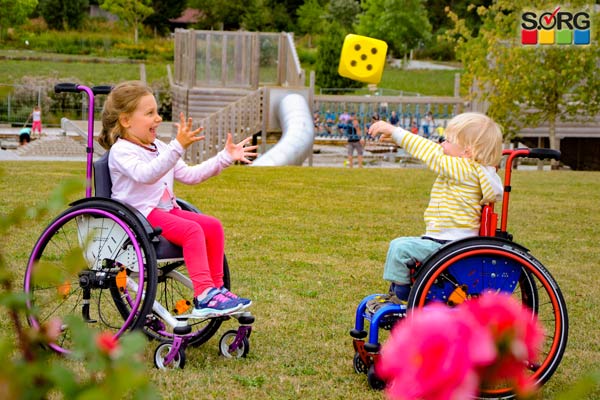Children's wheelchairs in the park, children in wheelchairs playing and laughing 